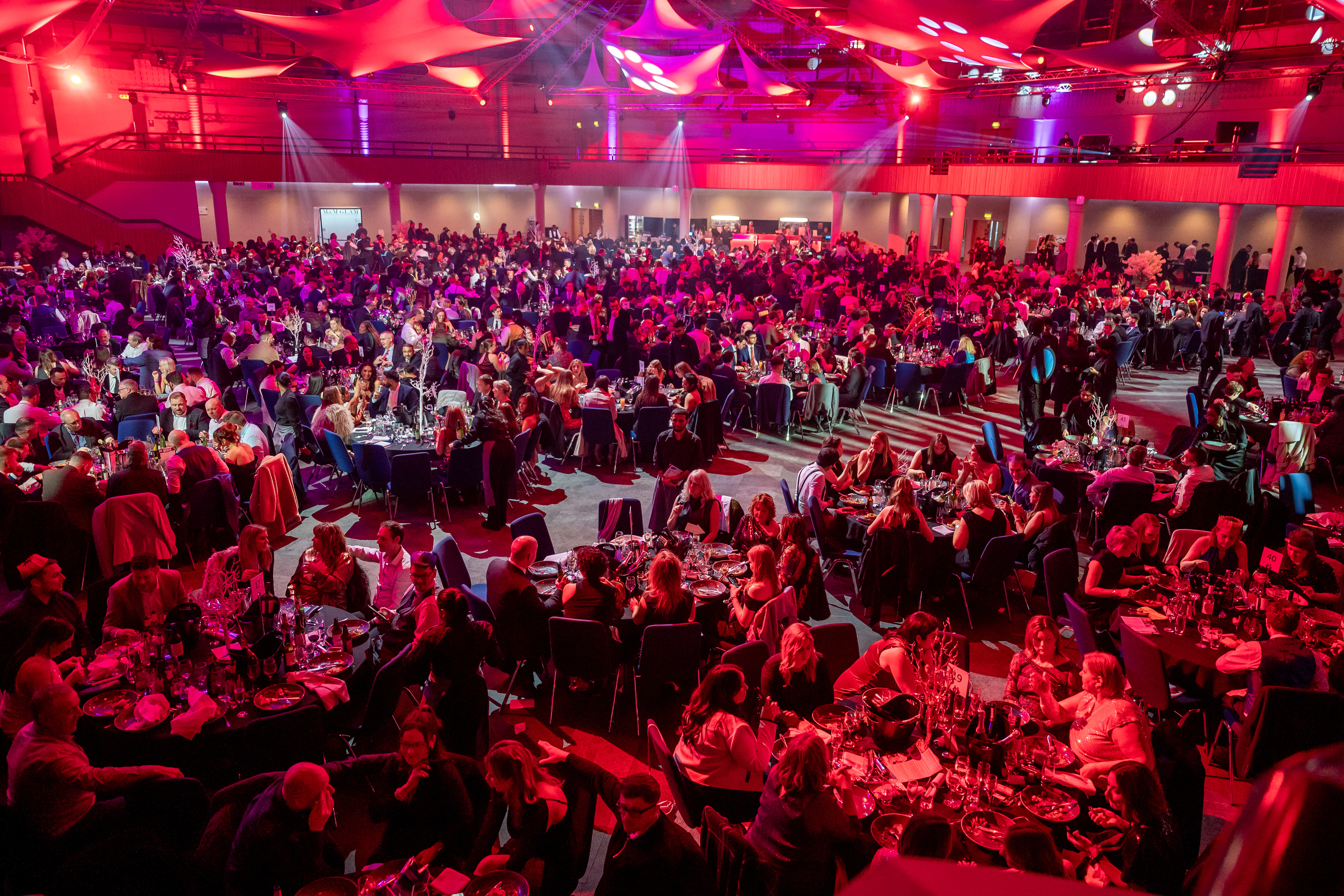 Guests at a Christmas party night at the ICC Birmingham &mdash; full room, production lighting and 3-course dinner