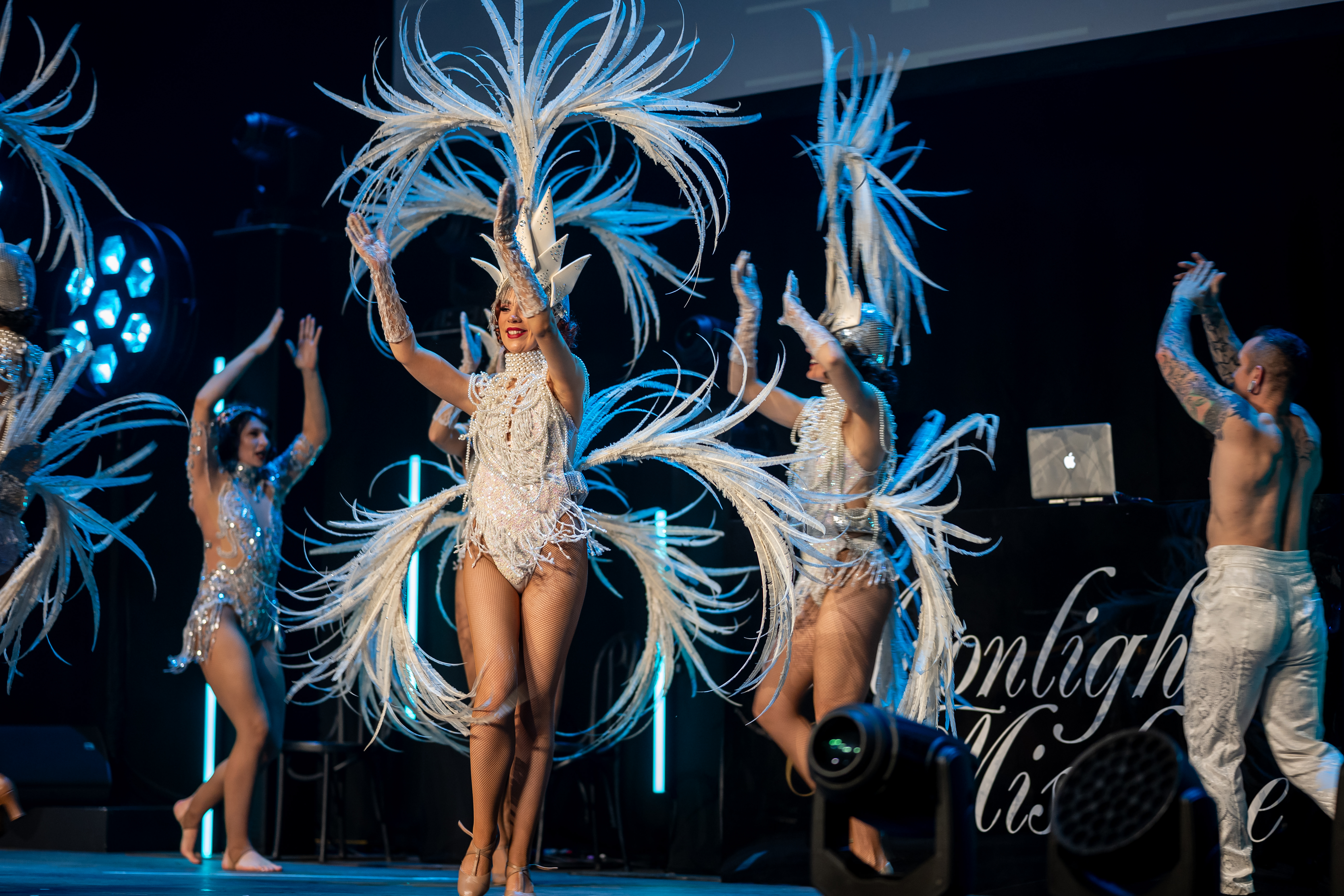 Live cabaret entertainment at a Moonlight & Mistletoe Christmas party night at Empire Banqueting Hall Leicester — performers in white feathered costumes on stage