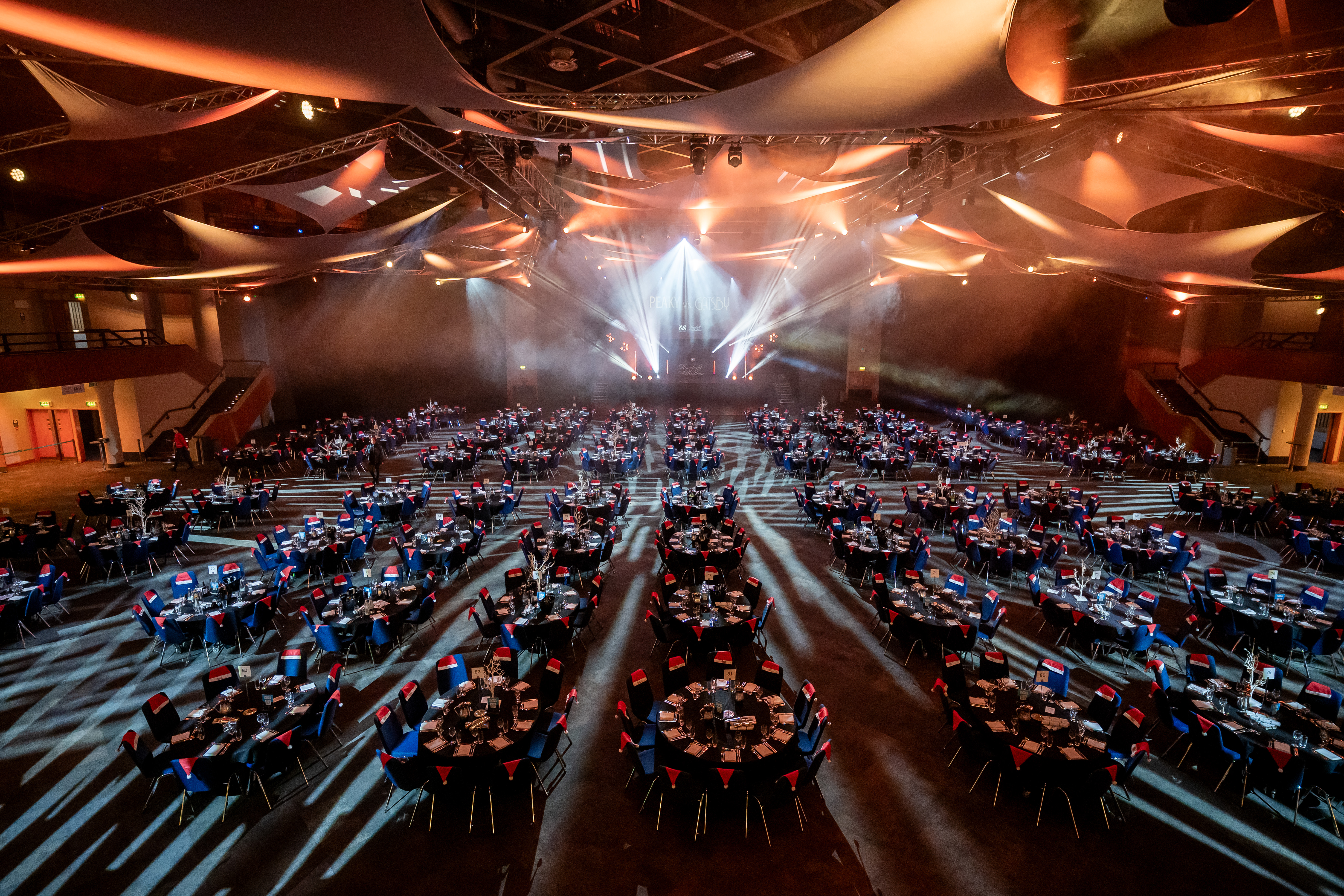 ICC Birmingham Hall set up for Moonlight & Mistletoe Christmas party night — tables, theming and stage