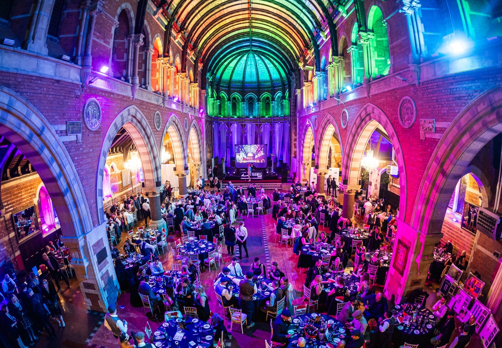 Christmas party night at Empire Banqueting Hall Leicester — guests dining under the Grade II-listed vaulted ceiling with coloured production lighting