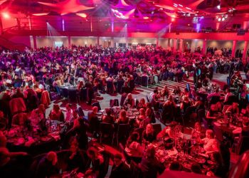 Guests at a Christmas party night at the ICC Birmingham — full room, production lighting and 3-course dinner