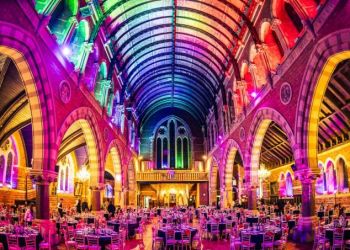Empire Banqueting Hall interior set for a Christmas party — Grade II-listed venue with vaulted arched ceilings, circular dinner tables and Chiavari chairs, and full production festive lighting